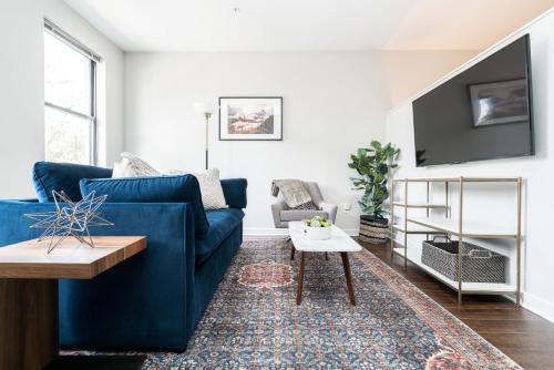 a living room with a blue couch and a table at CozySuites MusicRow Astonishing Studio with free parking 37 in Nashville