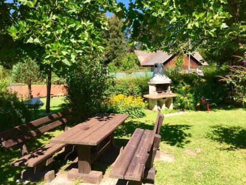 a wooden bench and a bird feeder in a garden at Georgihof im Park in Unterburg am Klopeiner See