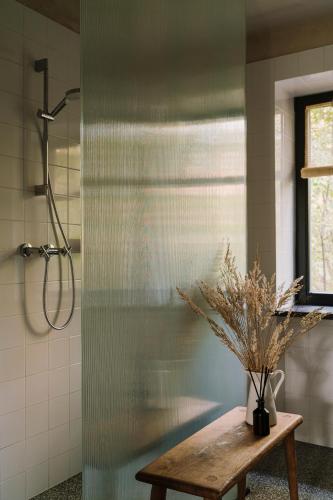 a bathroom with a shower with a wooden table and a bench at Gniazdowo nad rzeką - dom z sauną i masażem in Łochów
