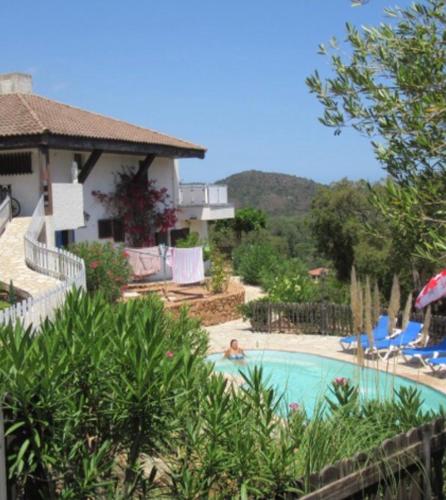 une personne se posant dans une piscine à côté d'une maison dans l'établissement Maison Le Guetali, à Sainte-Lucie de Porto-Vecchio