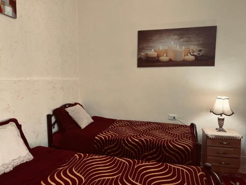a bedroom with a bed and a dresser with a lamp at IBN Khaldoon in Madaba