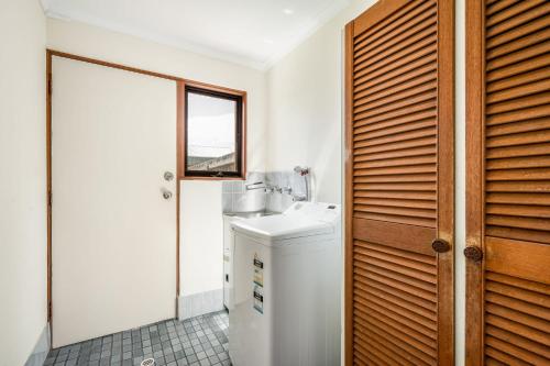 a bathroom with a sink and a washing machine at Beachfront Views at Southern Sands 1 in Port Elliot