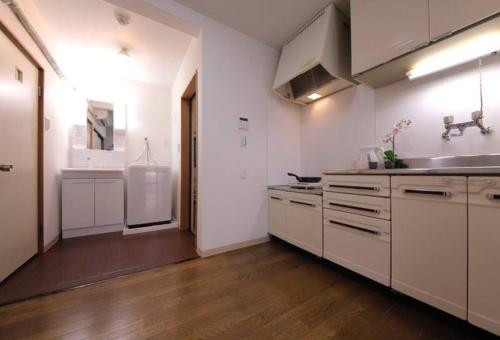 a large kitchen with white cabinets and a sink at Osaka SENJU2 traditional Tatami whole house 2-5 ppl 3 mins walk to station in Osaka