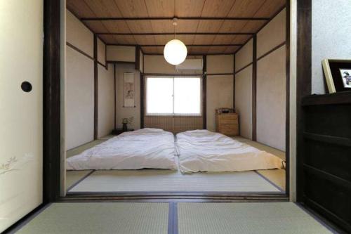 a bedroom with a large bed in a mirror at Osaka SENJU2 traditional Tatami whole house 2-5 ppl 3 mins walk to station in Osaka