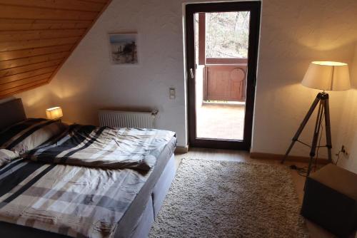 a bedroom with a bed and a window and a lamp at Ambiente Chalet Julienhöhe in Niederdorf