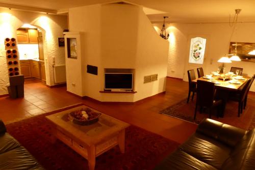 a living room with a table and a dining room at Ambiente Chalet Julienhöhe in Niederdorf