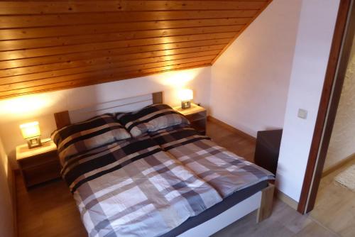 a bedroom with a bed with two lamps on two tables at Ambiente Chalet Julienhöhe in Niederdorf