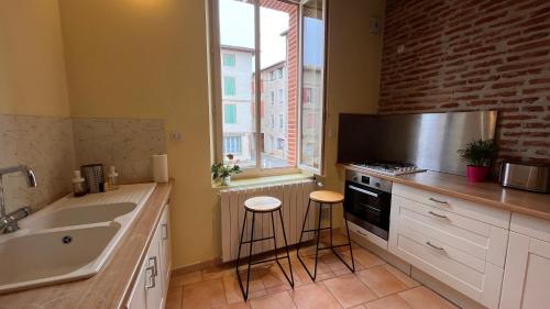 une cuisine avec un évier et une cuisinière dans l'établissement Le Gite d Eugenie, à Gaillac