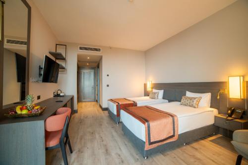a hotel room with two beds and a television at Hotel Pia Bella in Kérynia