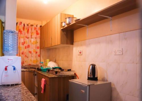 una pequeña cocina con fregadero y nevera. en Santaq villas apartment en Nairobi