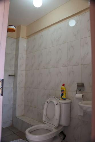 y baño con aseo y lavamanos. en Santaq villas apartment en Nairobi