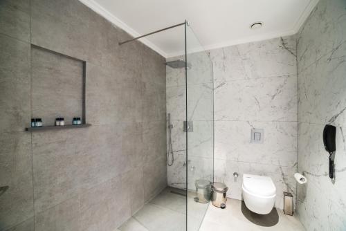 a bathroom with a glass shower and a toilet at Hotel Pia Bella in Kérynia