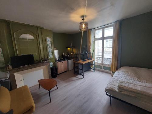 a bedroom with a bed and a desk and a window at Studio centre ville la Flèche proche zoo in La Flèche