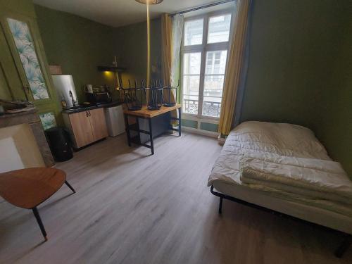 a bedroom with a bed and a table and a window at Studio centre ville la Flèche proche zoo in La Flèche