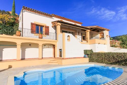 a villa with a swimming pool in front of a house at SELECT'SO HOME - Villa PANORAMA - Services hôteliers & prestations de qualité in Le Lavandou