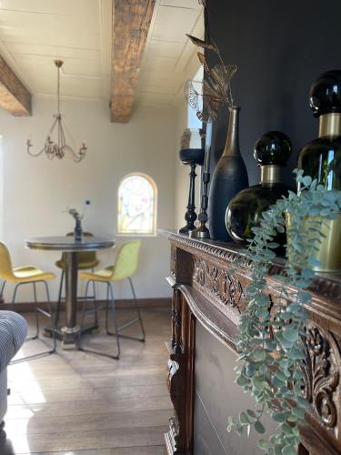 a room with a counter with vases and a table at B&B Het Molenhuisje Winschoten - met woonkamer & keuken in Winschoten