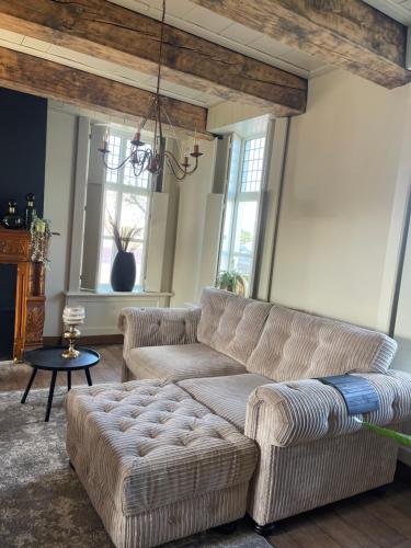a living room with two couches and a table at B&B Het Molenhuisje Winschoten - met woonkamer & keuken in Winschoten