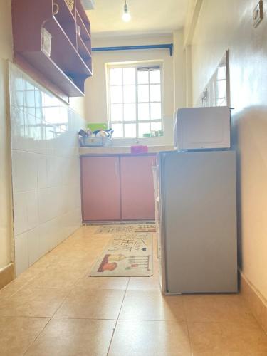 a kitchen with a refrigerator in a room at The Cream Loft in Eldoret