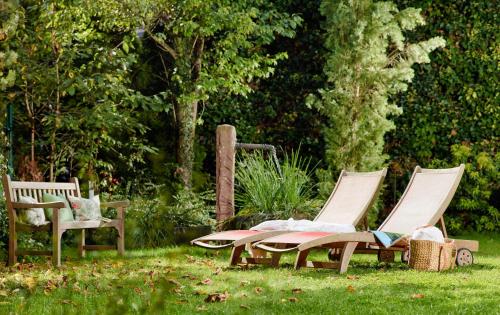 a group of three chairs sitting in the grass at Ringhotel Bömers Mosel Landhotel in Alf