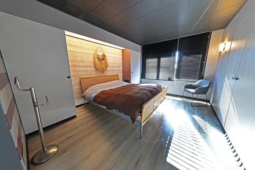 een slaapkamer met een bed, een raam en een stoel bij Villa Fantasia in Spa