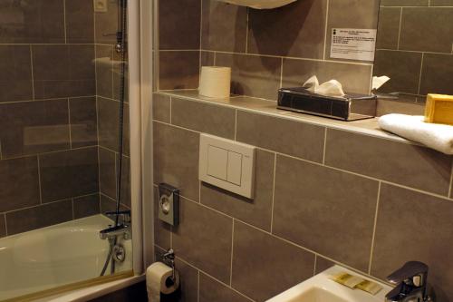 a bathroom with a sink and a bath tub at Hôtel Edmond Rostand in Marseille