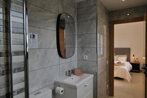 a bathroom with a sink and a mirror and a bed at Villa de lujo EL MIRADOR in L'Ampolla