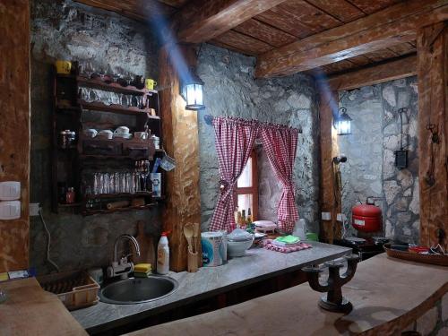 a kitchen with a sink and a counter with a window at Kuća za odmor Grujić in Kolašin