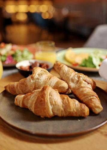 a plate of bread and croissants on a table at Chop Old House Hotel in Velika Gorica