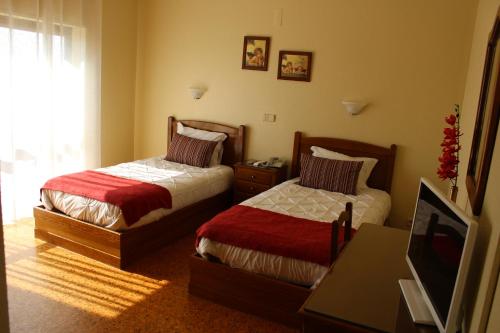 Cette chambre comprend deux lits et une télévision. dans l'établissement A Muralha, à Almeida