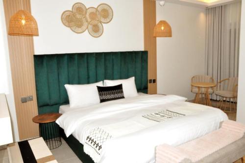 um quarto com uma cama grande e uma cabeceira verde em مساكن الدار 10 em Abha