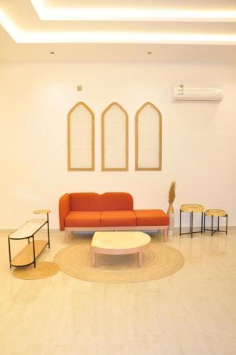 a living room with a red couch and two tables at مساكن الدار للشقق الفندقية 10 in Abha