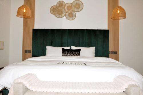 a bedroom with a large white bed with a green headboard at مساكن الدار للشقق الفندقية 10 in Abha