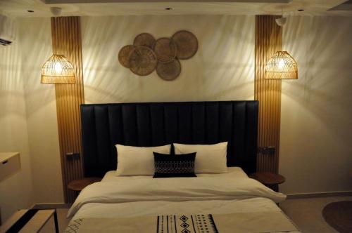 a bedroom with a large bed with a black headboard at مساكن الدار للشقق الفندقية 10 in Abha