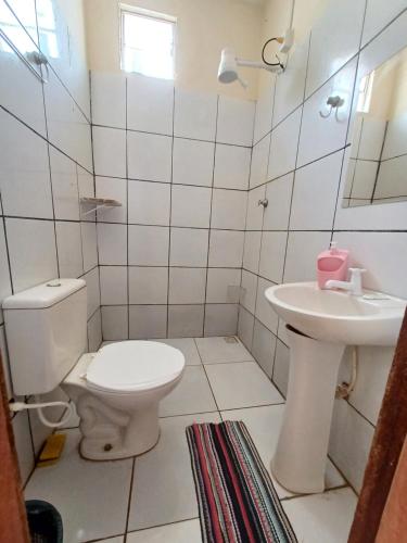 a white bathroom with a toilet and a sink at CASA DE TEMPORADA NOSSO CANTINHO A in Carolina