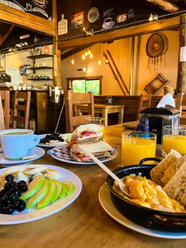 a wooden table topped with plates of food and drinks at Las Bravas Lodge in Las Trancas