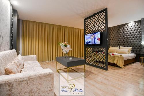 a living room with a couch and a tv at Hotel Pia Bella in Kérynia
