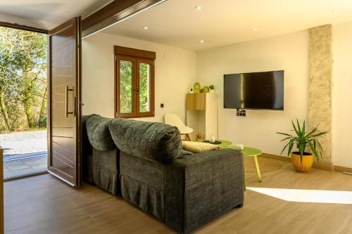 a living room with a couch and a flat screen tv at Casa Iria in Lousame