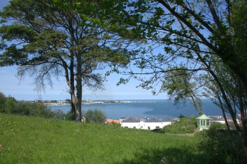 a view of a lake from a hill with trees at Les Cotils in Saint Peter Port