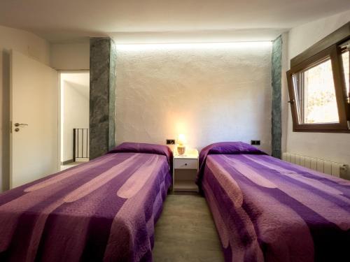 2 camas en una habitación con sábanas moradas en Casa Iria en Lousame