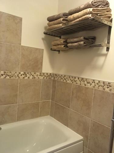 a bathroom with a tub and some towels on a wall at Apiary Mews in Newcastle