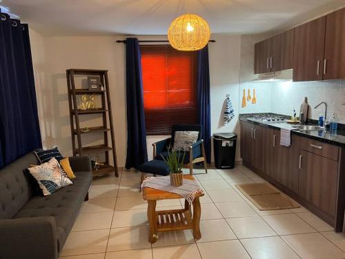 eine Küche und ein Wohnzimmer mit einem Sofa und einem Tisch in der Unterkunft Romantic place savaneta near several beaches in Savaneta