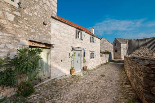 a cobblestone alley in an old stone building at Mala House - Šolta Island in Grohote