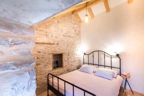 Bett in einem Zimmer mit einer Steinmauer in der Unterkunft Mala House - Šolta Island in Grohote