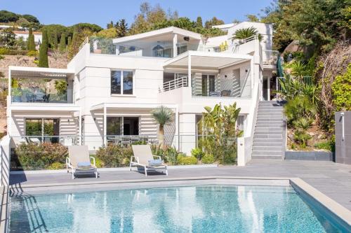 une maison blanche avec une piscine devant dans l'établissement HIBISCUS PENTHOUSE, à Cannes