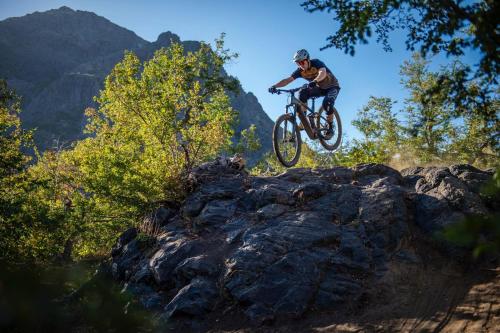 a man jumping a bike over some rocks at Las Bravas Lodge in Las Trancas