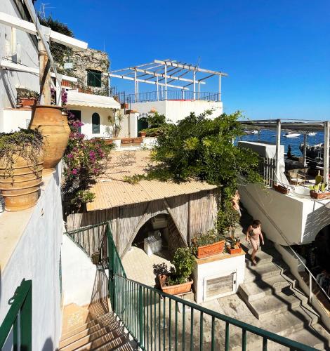 a person walking down a staircase with potted plants at Capri Suite on the beach in Capri