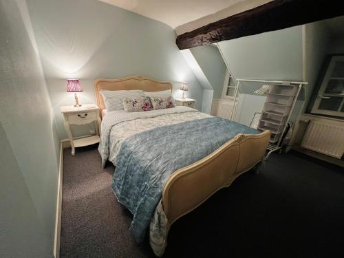 a bedroom with a large bed and two night stands at A La Maison - hébergement de luxe in Domfront