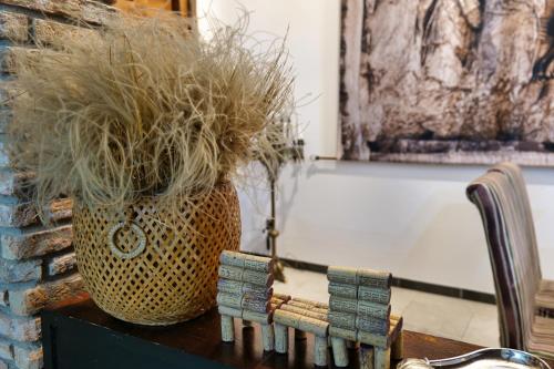 a vase filled with grass sitting on top of a table at La Sinagoga in Peñaranda de Duero