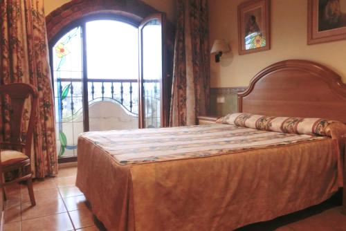 a bedroom with a bed and a large window at Hotel Las Ruedas in Laredo