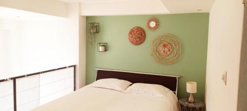 a bedroom with a bed and a green wall at 35m2, luminous loft close to the beach in Villefranche-sur-Mer